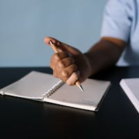 Female speaker presenting to an audience in a modern auditorium setting.