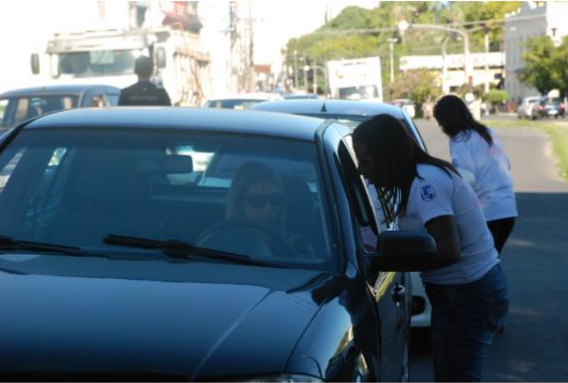 Vereadora Daiane Dias distribuindo material informativo às condutoras. Foto: divulgação.