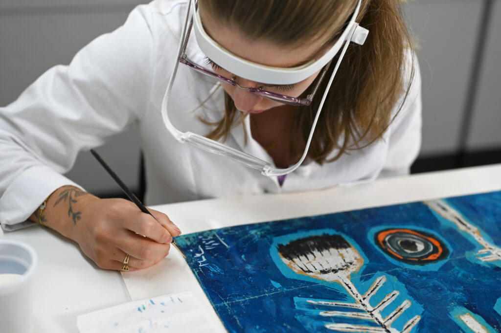 Processo de restauração da obra "Pássaro", de Martin Bradley, conduzido pela equipe do LACORPI no laboratório do Palácio da Alvorada, com foco na preservação do guache sobre papel.