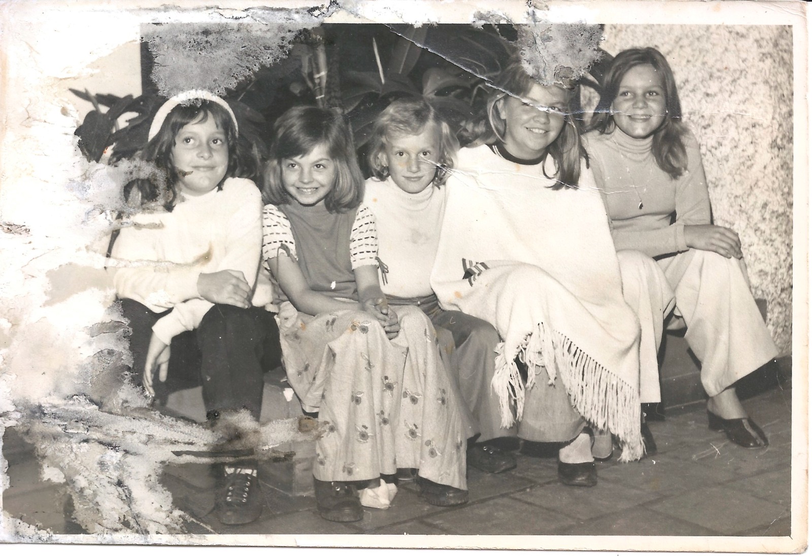 Fotografia em preto e branco antes de ser restaurada: crianças sentadas.